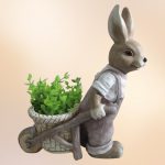 Kerti dekoráció, MagicHome Gecco, nyuszi talicskával, barna, 42 x 19 x 49 cm, magnézia, egyben virágtartó is